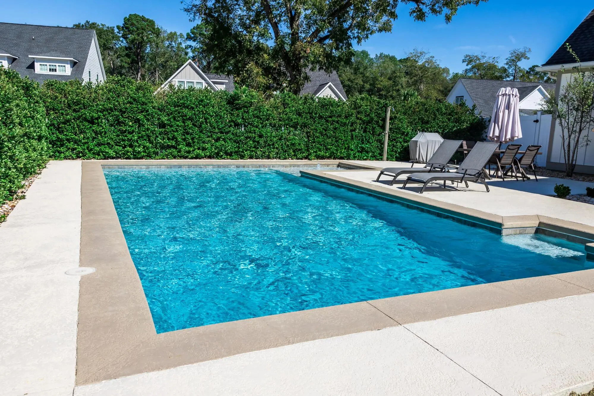 Backyard swimming pool with lounge chairs.