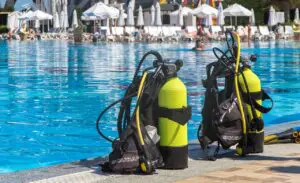 Scuba diving gear by a poolside.
